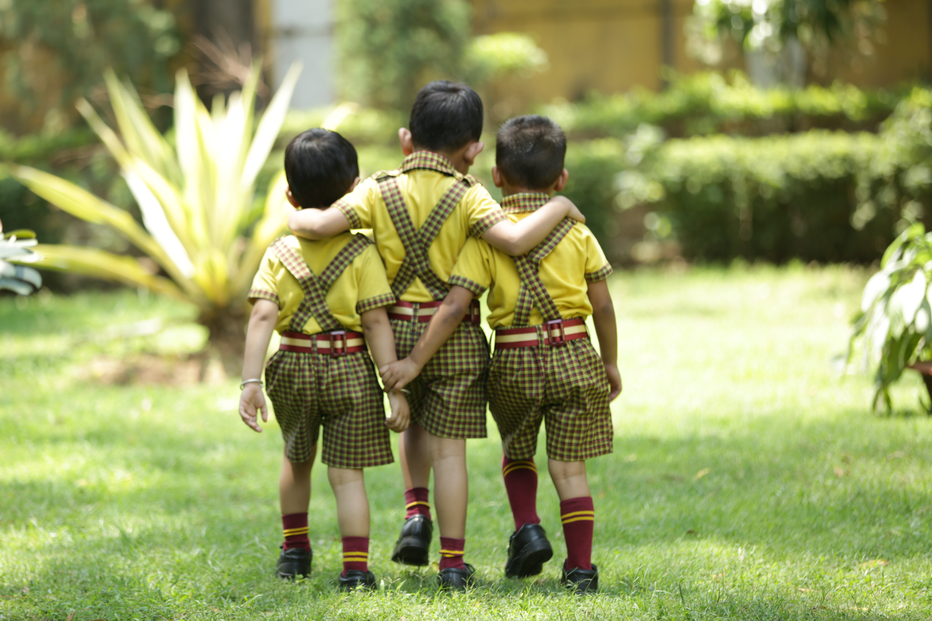 Three young friends walking arm in arm